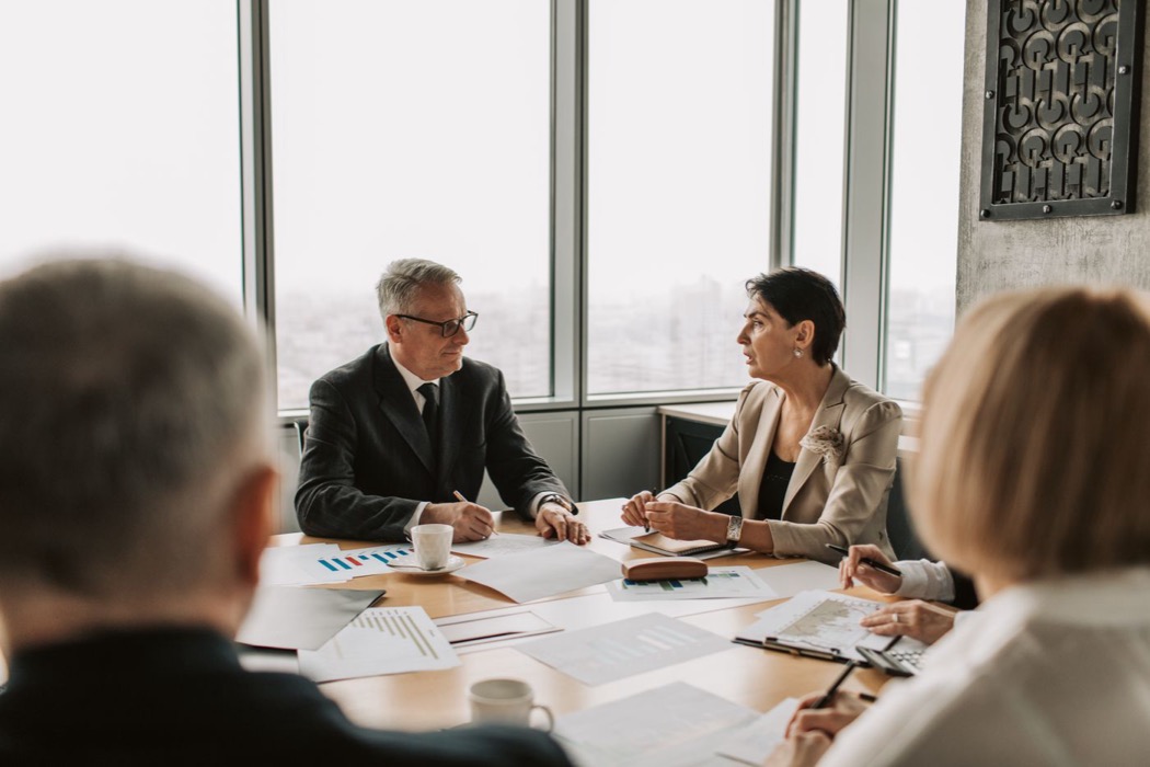 Executives in discussion around a boardroom table